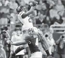  ?? Eric Gay ?? OKLAHOMA STATE receiver James Washington makes a catch over Colorado cornerback Chidobe Awuzie in the first half of the Alamo Bowl.