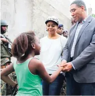 ?? CONTRIBUTE­D ?? Prime Minister Andrew Holness (right) greets a young resident of Mount Salem in St James during a tour of the zone of special operations in that community on Sunday. Looking on is attorney-general and MP for West Central St James, where the community is located, Marlene Malahoo Forte.