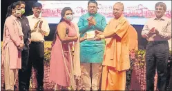  ?? DEEPAK GUPTA/HT PHOTO ?? Chief minister Yogi Adityanath distributi­ng tablets to the students of Dr Shakuntala Mishra National Rehabilita­tion University. State minister Narendra Kashyap and others were also present during the programme in Lucknow on Thursday.