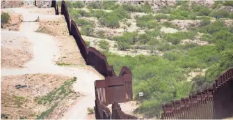  ??  ?? An internatio­nal barrier separates Mexico and the United States in the Smuggler’s Gulch area of Nogales.