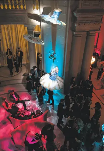  ?? Laura Morton / Special to The Chronicle ?? San Francisco Ballet costumes hang from the ceiling of City Hall during the gala’s after-party.