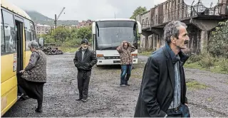  ?? BRENDAN HOFFMAN GETTY IMAGES ?? People wait for the arrival of civilians leaving fighting in Nagorno-karabakh on Tuesday. Armenia and Azerbaijan continued trading attacks in and around the contested territory.