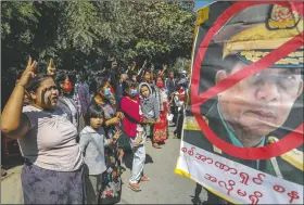  ??  ?? Demonstrat­ors shout slogans and flash the three-fingered symbol of resistance against the military coup standing next to a defaced image of Myanmar military Commander-in-Chief Senior Gen. Min Aung Hlaing in Mandalay.