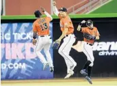  ?? LYNNE SLADKY/ASSOCIATED PRESS ?? Marlins outfielder­s Marcell Ozuna (13), Giancarlo Stanton (center) and Ichiro Suzuki celebrate after Sunday’s win.