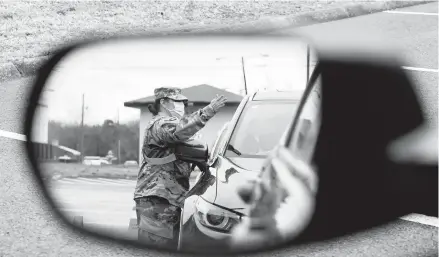  ?? MARK HUMPHREY/AP ?? A National Guard member directs motorists waiting in line at a COVID-19 vaccinatio­n site last week in Shelbyvill­e, Tennessee.