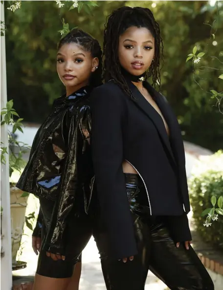  ?? AP FILE ?? DEVOTED DUO: Sisters Halle and Chloe Bailey, from left, of the R&B duo Chloe x Halle, pose in their backyard in Los Angeles to promote the release of ‘Ungodly Hour.’