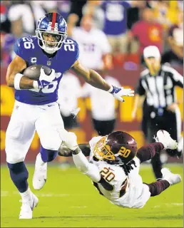  ?? AP ?? FUN RUN: Saquon Barkley brushes aside Washington cornerback Bobby McCain’s attempted tackle as the Giants running back breaks off a 41-yard run in the first quarter Thursday night in Landover, Md.