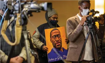  ??  ?? A man holds a portrait of George Floyd during press conference on the third day jury selectiona­t the trial of Derek Chauvin on Wednesday in Minneapoli­s, Minnesota. Photograph: Kerem Yucel/AFP/Getty Images