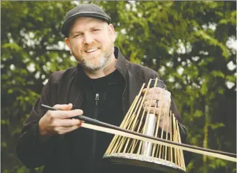  ?? JULIE OLIVER ?? Carleton University music professor Jesse Stewart plays a waterphone instrument outside his Ottawa home. Stewart has been posting videos online of himself playing various instrument­s.