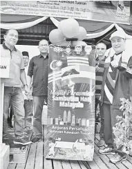  ??  ?? RASMI: Hajiji (kanan) ketika merasmikan sambutan Hari Malaysia anjuran Persatuan Nelayan Kawasan Tuaran di Mengkabong.