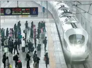  ?? ZHANG YIXI / FOR CHINA DAILY ?? Passengers wait as a train pulls into Luoyang Longmen Railway Station in Henan province on Feb 14. The 40-day Spring Festival travel rush ended on Feb 15.