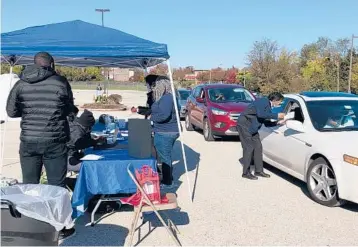  ?? CARMEN GUERRA ?? Volunteers at a flu shot event in Pennsylvan­ia also distribute­d test kits to detect possible signs of colon cancer.