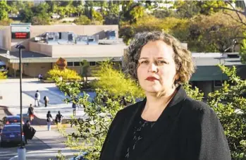  ?? EDUARDO CONTRERAS U-T ?? Happy Feliz Aston stands in front of Patrick Henry High School on Friday. She is a parent of two gradeschoo­l students who are on track to attend the high school and is upset it has cut several honors courses.