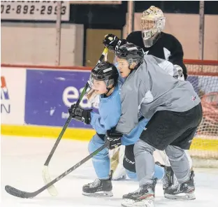  ?? JASON MALLOY/THE GUARDIAN ?? Justin Gill, right, and Thomas Casey battle for position in front of goalie Colten Ellis during Wednesday’s Charlottet­own Islanders practice.