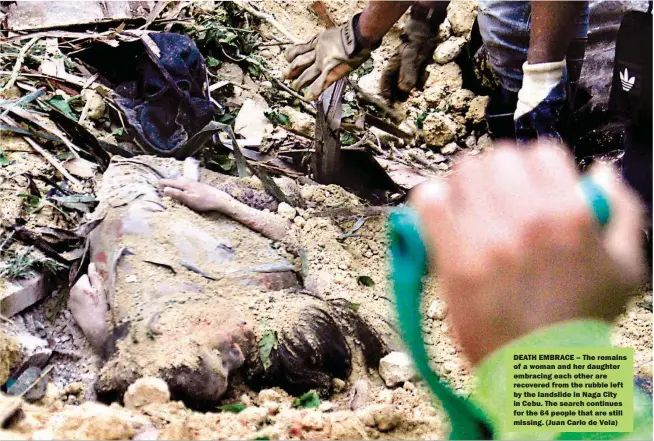  ??  ?? DEATH EMBRACE – The remains of a woman and her daughter embracing each other are recovered from the rubble left by the landslide in Naga City in Cebu. The search continues for the 64 people that are still missing. (Juan Carlo de Vela)