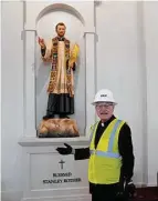  ?? ?? The Rev. Don Wolf, a cousin, stands by a statue of Stanley Rother. Wolf will serve as the shrine’s first rector.