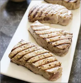  ?? DANIEL J. VAN ACKERE/AMERICA’S TEST KITCHEN VIA THE ASSOCIATED PRESS ?? This undated photo provided by America’s Test Kitchen shows grilled tuna steaks with vinaigrett­e in Brookline, Mass.