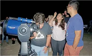  ??  ?? Hasan Al Hariri monitors the arrangemen­ts to watch the Perseids Meteor shower in Al Qudra desert, Dubai, on Sunday. Right, people line up to watch the meteor shower.