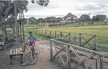  ??  ?? Un joven residente pasea en bicicleta cerca de los talleres