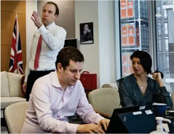  ??  ?? In Whitehall: Matt Hancock in his office with Gina Coladangel­o and other staff