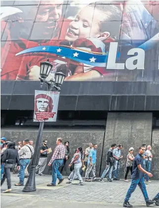  ??  ?? En Caracas, largas filas para extraer dinero de un cajero automático