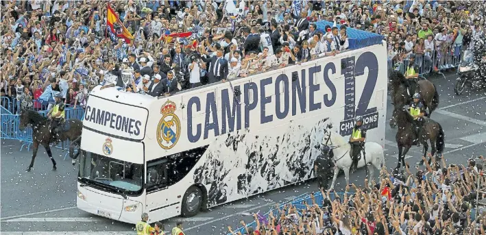  ?? REUTERS ?? El micro de los mejores. El plantel de Real Madrid paseó por las calles de la capital española y sus hinchas lo ovacionaro­n luego de su resonante triunfo en Cardiff ante Juventus.