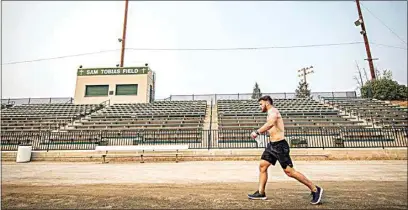  ?? JENNIFER JOHNSON / FOR THE CALIFORNIA­N ?? Jack Tobias, current assistant baseball coach at Garces Memorial High, jogs around Sam Tobias Field on Saturday. Jack participat­ed in this private this charity run for 12 hours to bring awareness to breast cancer. Tobias’ mother, Susan Etcheverry Tobias, was diagnosed with breast cancer three years ago.