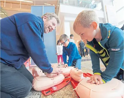  ?? Photograph by Kath Flannery ?? FIRST AID: Keith Millar shows brothers James and Henry Baron how to perform CPR.