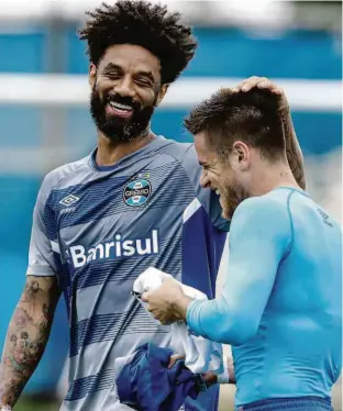  ?? Lucas Uebel/Grêmio FBPA ?? O volante Cristian passa a mão na cabeça de Ramiro durante treino do Grêmio; ex-corintiano faz hoje, contra o Fluzão, seu primeiro jogo pelo Tricolor gaúcho