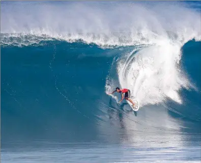  ?? WSL / CESTARI ?? BOMBING IN: Mikey February drops in on a backdoor bomb at Pipeline during the Pipeline Invitation­al.