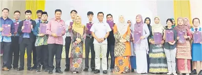  ?? ?? KENANGAN: Tah Nia dan Timbalan Menteri Pendidikan, Datuk Mohamad Alamin merakamkan gambar kenangan bersama pelajar cemerlang SPM 2021 di Kota Kinabalu semalam.