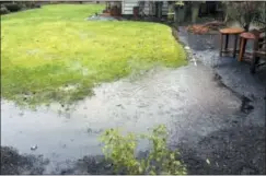  ?? DEAN FOSDICK VIA AP ?? This photo shows water pooling in low spot on a homeowners lawn near Langley, Wash. The financial costs of poor drainage on properties can be substantia­l. Prevention is the cure. Low spots on the landscape can be hard to see but areas where the ground...