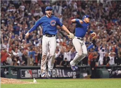 ?? GETTY IMAGES ?? Kris Bryant (left) and Addison Russell of the Chicago Cubs celebrate after defeating the Cleveland Indians in game seven of the 2016 World Series. The Cubs won their first World Series in 108 years.
