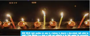  ??  ?? NEW DELHI: Light candles are seen in a balcony to observe a nine-minute vigil called by India’s Prime Minister in a show of unity and solidarity in the fight against the coronaviru­s pandemic. — AFP