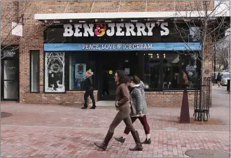  ?? CHARLES KRUPA — THE ASSOCIATED PRESS ?? Pedestrian­s walk on Church Street past the Ben & Jerry’s shop in Burlington, Vt., in 2020. Unilever, the company that makes Ben & Jerry’s ice cream, said Tuesday it is cutting 7,500jobs and spinning off its ice cream business.