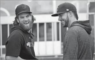  ?? NICK WASS/AP SPORTS ?? Bryce Harper of the Nationals, left, laughs with Kris Bryant of the Cubs, right, during practice on Thursday at Nationals Park in Washington.