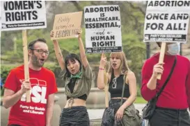  ?? ASHLEE REZIN/SUN-TIMES ?? Angelina Han, 20, and Emma Macfadyen, 20, both from Chicago, join other abortion rights activists on Michigan Avenue in the Loop on Wednesday.