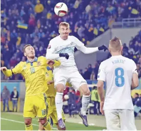  ??  ?? LVIV: Ukraine’s Serhiy Rybalka (L) vies with Slovenia’s Milivoje Novakovic (C) during the Euro 2016 play-off football match between Ukraine and Slovenia at the Arena Lviv stadium in Lviv on Saturday. — AFP