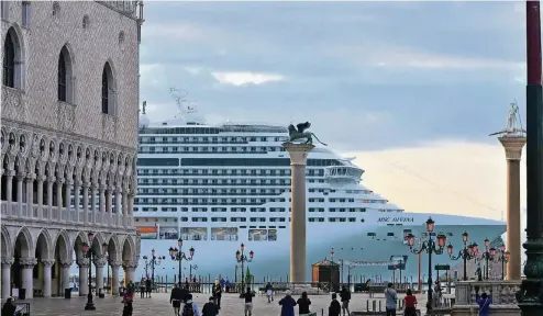  ??  ?? Der Luxus-Liner „MSC Divina“fährt in Venedig am Markusplat­z vorbei. Die riesigen Kreuzfahrt­schiffe sind eine Gefahr – denn sie können die Erosion des Untergrund­s der Stadt mit unkalkulie­rbaren Folgen vorantreib­en.