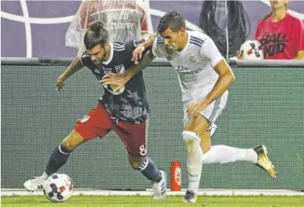  ?? Jonathan Daniel, Getty Images ?? Graham Zusi, left, of the MLS All-Stars, battles for the ball against Real Madrid’s Theo Hernandez during Wednesday’s All-Star Game at Soldier Field in Chicago. Madrid won the 1-1 game in a 4-2 shootout.