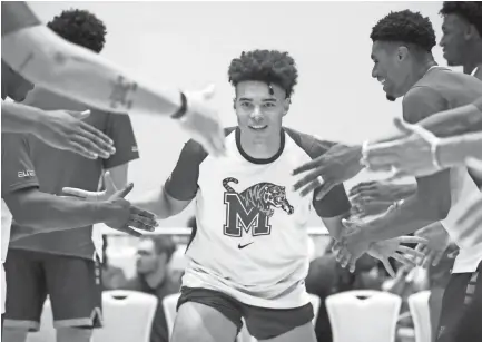  ?? JOE RONDONE/THE COMMERCIAL APPEAL ?? Memphis Tigers guard Lester Quinones high-fives teammates as he is introduced as a starter against the Commonweal­th Bank Giants during their exhibition on Wednesday.