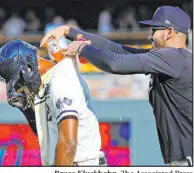  ?? Bruce Kluckhohn The Associated Press ?? Michael A. Taylor gets doused with Gatorade by Twins pitcher Pablo Lopez after drawing a bases-loaded walk in the 13th inning to end Minnesota’s 7-6 win over Texas on Sunday.