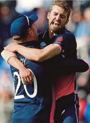  ?? REUTERS PIC ?? England’s Mark Wood (right) celebrates after taking the wicket of New Zealand’s Kane Williamson at Cardiff on Tuesday.