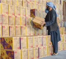  ?? — AFP ?? Afghan men work at a customs office warehouse in Herat on Monday.