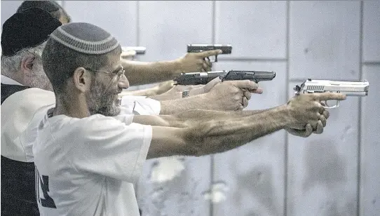  ?? ILIA YEFIMOVICH/GETTY IMAGES ?? Israelis practise at a shooting range Thursday in Jerusalem. Worried by a surge in Palestinia­n attacks, an increasing number of Israelis are arming themselves.