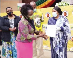  ??  ?? First Lady Auxillia Mnangagwa hands over a fish farming certificat­e to Ms Gumisai Katurudza,while Cde Marble Chinomona (left) and Cde Patrick Chi - namasa look on in Harare yesterday