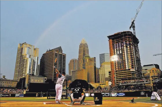  ?? JEFF SINER/THE CHARLOTTE OBSERVER ?? With a faint rainbow overhead, the skyline of Charlotte, N.C., provides a thriving backdrop for the Home Run Derby during the Triple-A All-Star Game festivitie­s Monday at BB&T Ballpark. The stadium, which opened in 2014, has fueled an attendance boom...