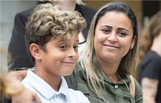  ?? ASHLEE REZIN/ SUN- TIMES ?? Sirley Silveira Paixao and her 10- year- old son, Diego Magalhaes, migrants from Brazil who were separated shortly after entering the United States seeking asylum, embrace Thursday during a news conference after they were reunited in Chicago.
