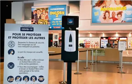  ??  ?? Safety measures: a dispenser of hand sanitiser gel placed inside a movie theatre in Paris. — aFP