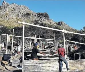  ?? PICTURE: DAVID RITCHIE ?? Victims of an Imizamo Yethu fire rebuild their homes. Decision makers and communitie­s will have to work together to discuss threats to justice whenever ‘resilience-building’ efforts are involved.